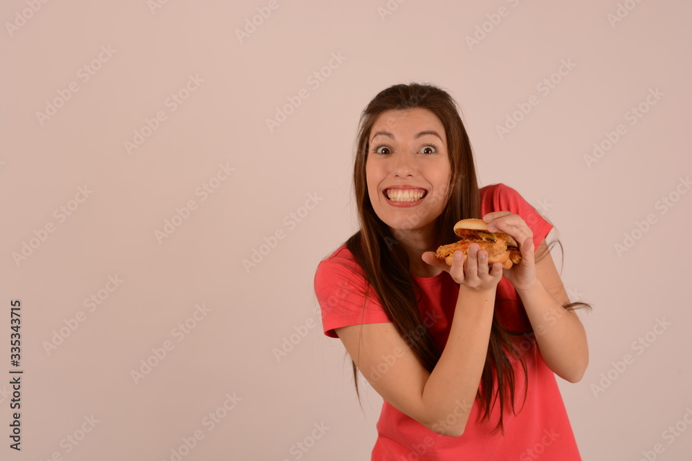 woman in t-shirt holding fast food burger in her hands