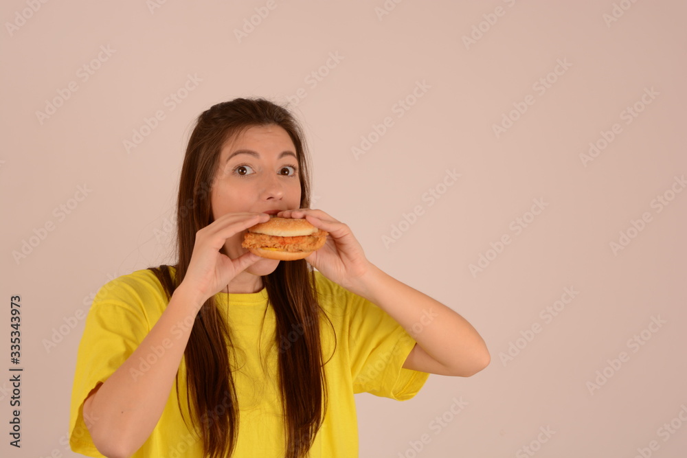 woman in a t-shirt with a burger in her hand advertising fast food place free woman in a t-shirt with a burger in her hand advertising fast food place free