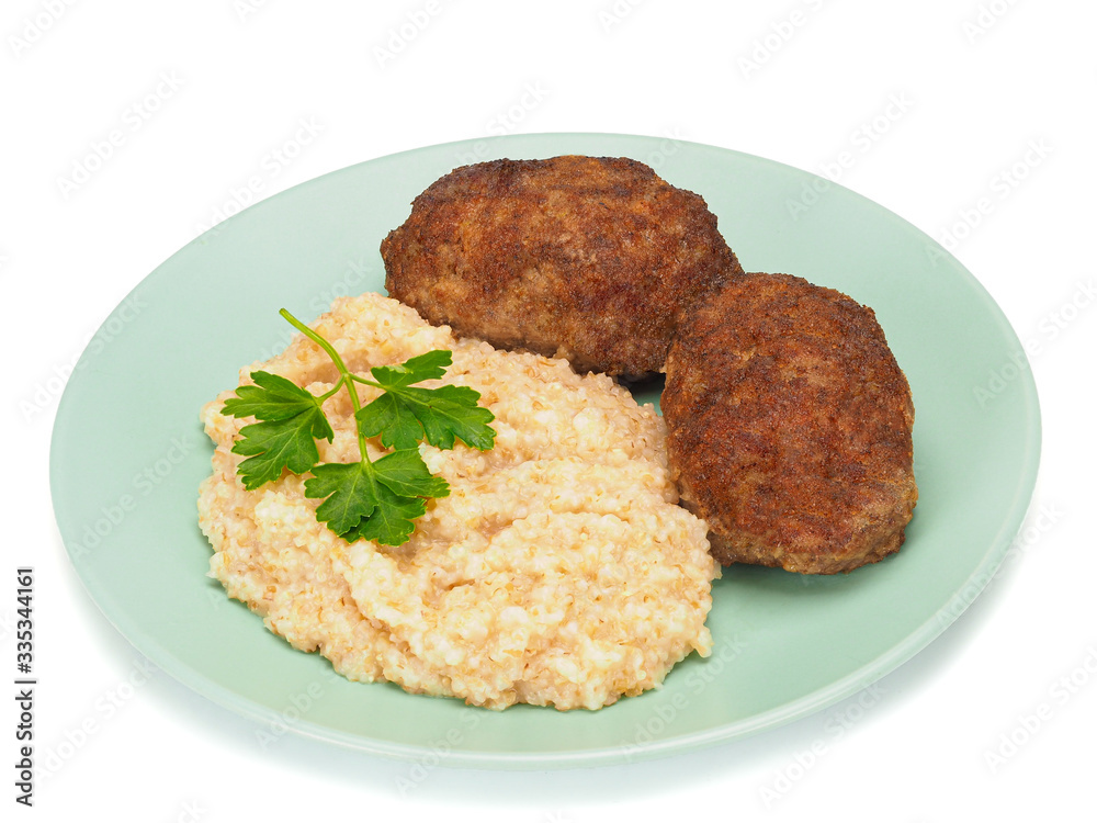 Homemade cutlets with wheat porridge on a plate and on white background. Homemade cutlets with wheat porridge on a plate and on white background.