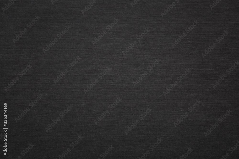 Texture of black fibrous paper, cardboard, closeup. Solid background, embossed surface.
