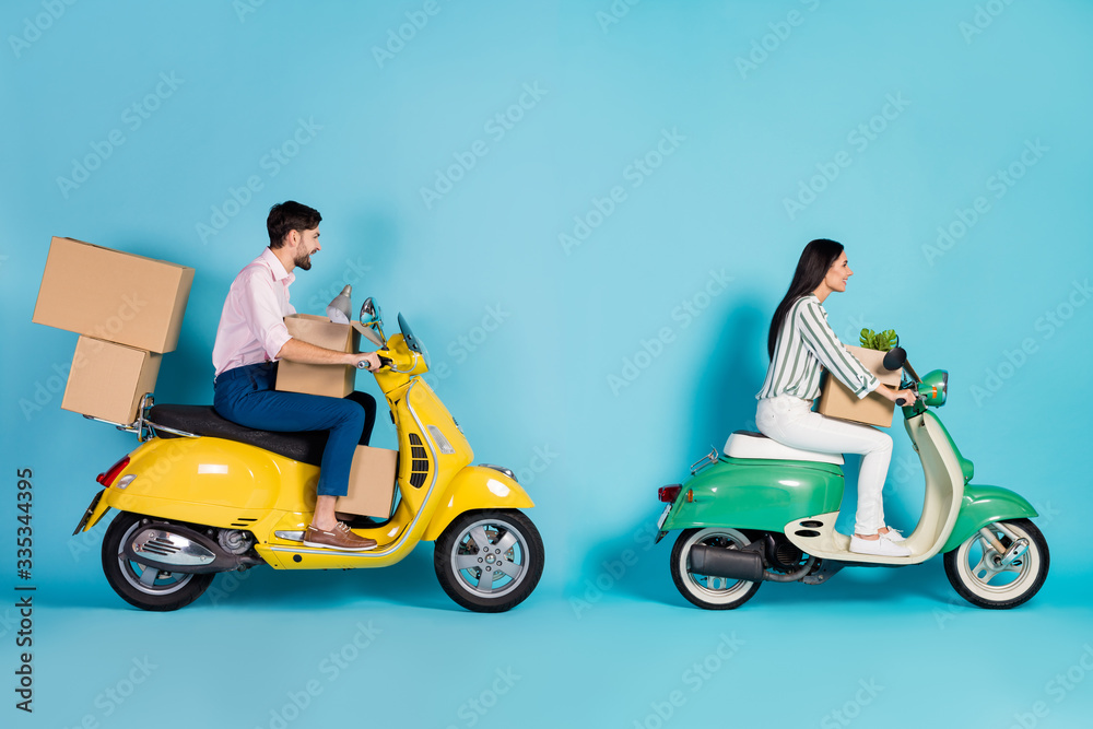 Full size profile side photo positive married couple rider driver get mortgage property move modern apartment drive motor bike carry packages lamp flower isolated blue color background Full size profile side photo positive married couple rider driver get mortgage property move modern apartment drive motor bike carry packages lamp flower isolated blue color background