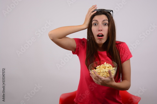 woman in a t-shirt with popcorn in her hands
