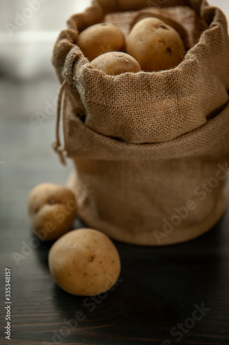 Potatoes in sackcloth on rustic wooden background