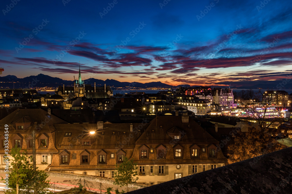 Vue nocturne de Lausanne depuis la Place de la Cathédrale au coucher du soleil (Suisse)