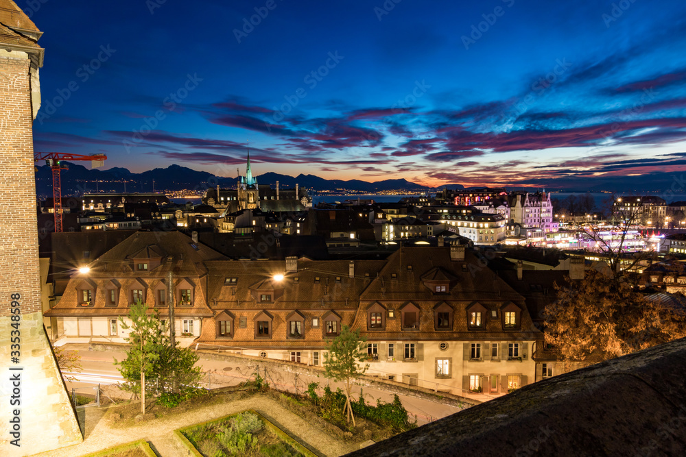 Vue nocturne de Lausanne depuis la Place de la Cathédrale au coucher du soleil (Suisse)