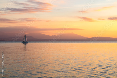 Coucher de soleil sur le Lac Léman où navigue un voilier et les montagnes des Alpes à Morges (Suisse) © Ldgfr Photos
