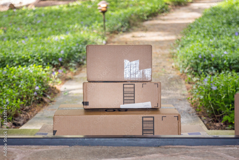 Φωτογραφία Recently delivered packages sit on a welcome mat in front of a wooden door to a residence