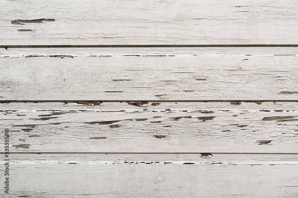 Wooden wall with bits and pieces of paint peeling off in a bright white color. Wooden wall with bits and pieces of paint peeling off in a bright white color.