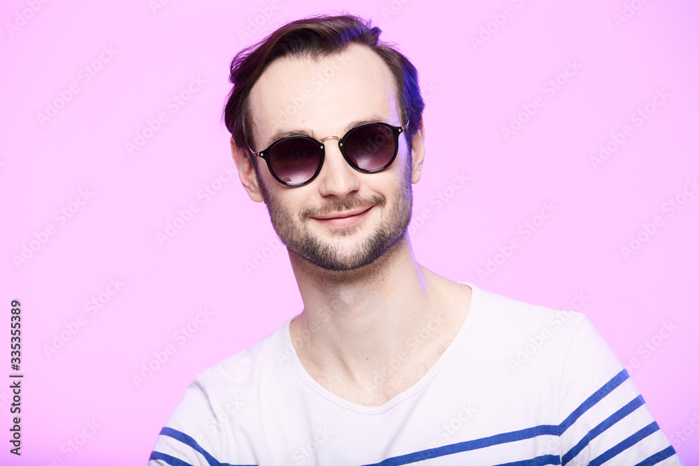 Studio shot of handsome man wearing sunglasses over pink background. Studio shot of handsome man wearing sunglasses over pink background.
