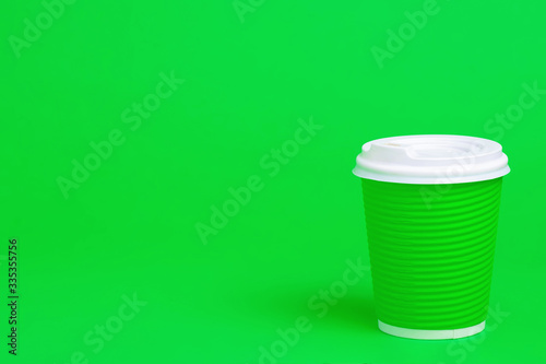 green cardboard cup of coffee on green background