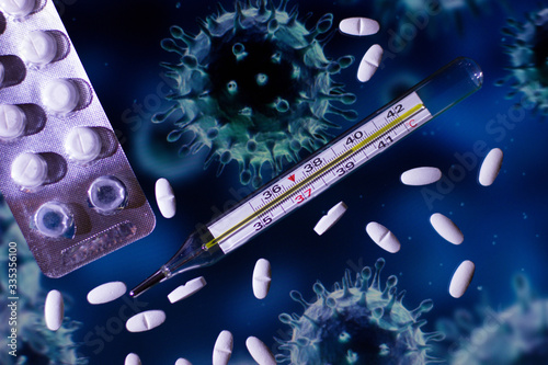 A thermometer and pills on the background of the coronavirus 
 
 The photo was taken at home, 3.04.2020 years, the background of the coronavirus, thermometer, pills 