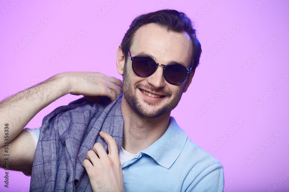 Studio shot of handsome man wearing sunglasses over pink background. Studio shot of handsome man wearing sunglasses over pink background.