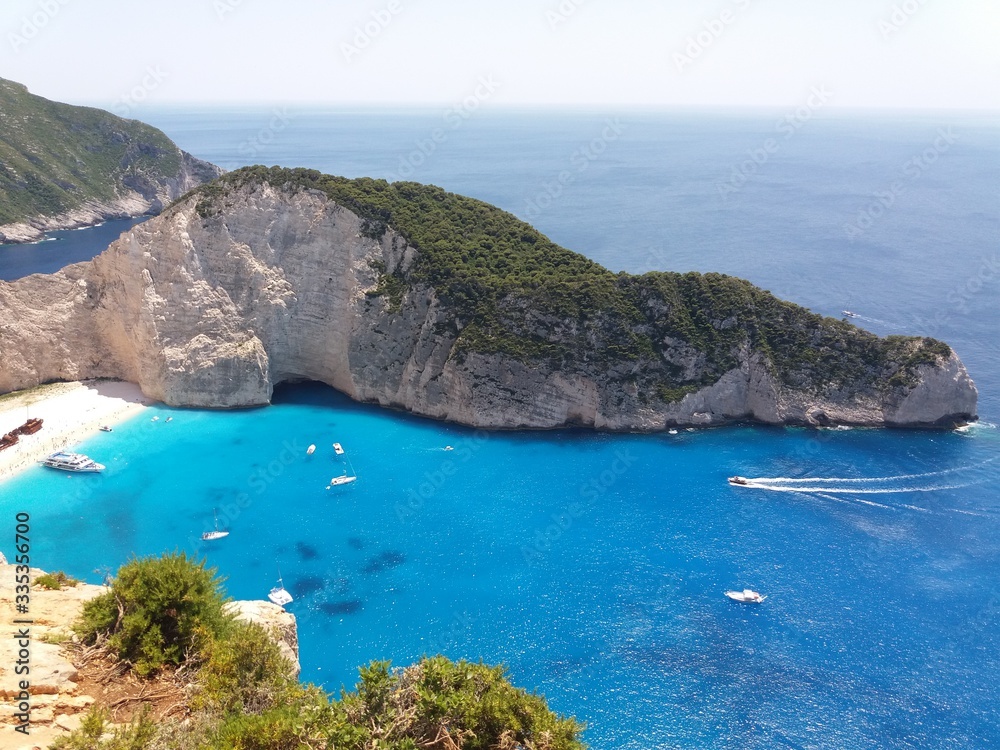 Navagio bay and beach with beautiful blue crystal clear, deep blue water, and the endless straight horizon in the background