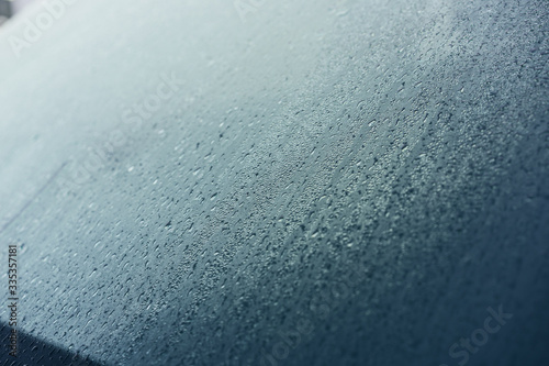 Raindrops on the hood of the car. Close-up.