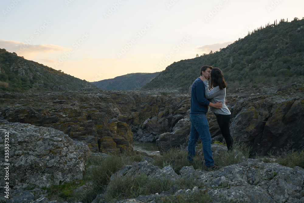 Couple kissing at Pulo do Lobo waterfall with river guadiana and rock details at sunset in Mertola Alentejo, Portugal