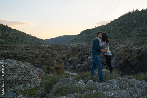 Couple kissing at Pulo do Lobo waterfall with river guadiana and rock details at sunset in Mertola Alentejo, Portugal