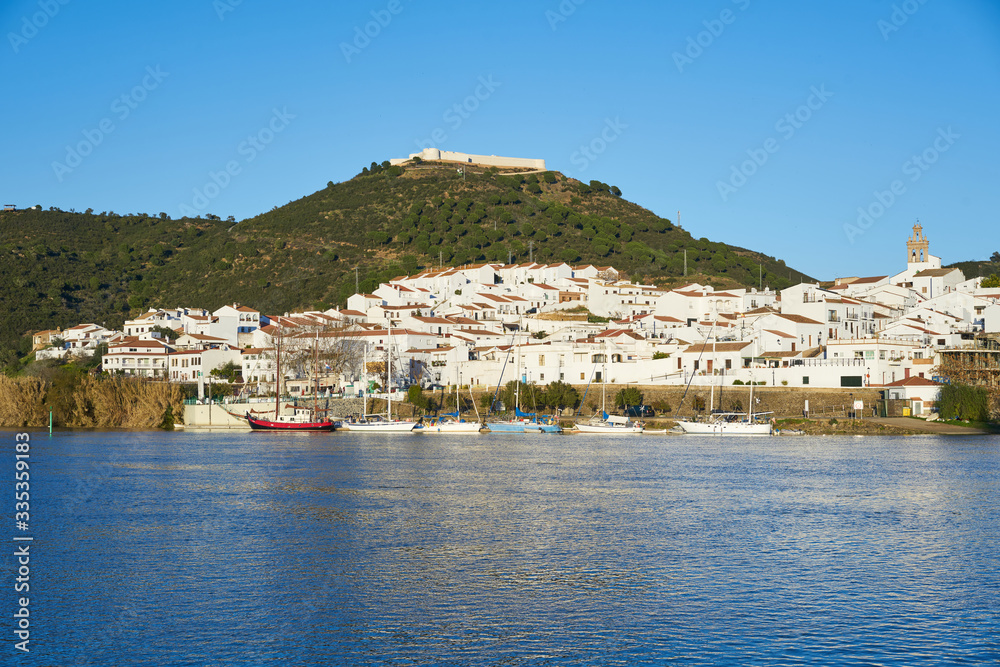 Sanlucar de Guadiana in Spain and Alcoutim in Portugal with sail boats on Guadiana river