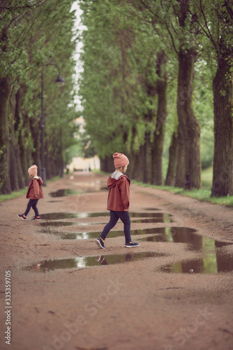 children run along the alley of trees