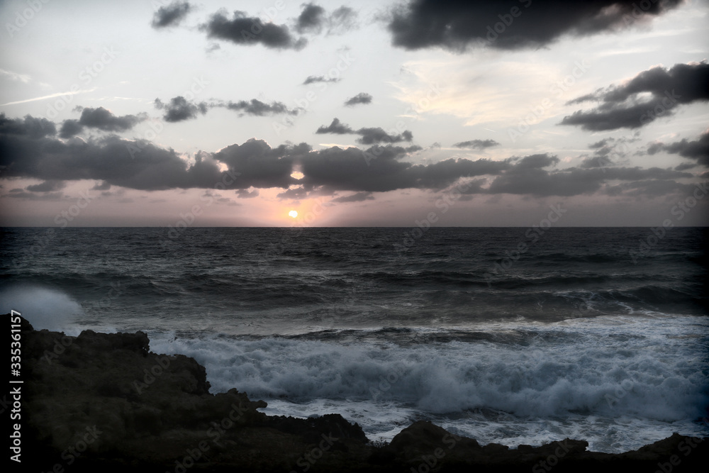Stormy sunset on the Mediterranean Sea. Evening. Rocky coast. Sea Caves, Peyia, Cyprus