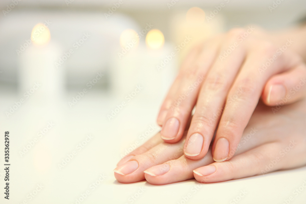 Closeup shot of a woman in a nail salon getting a manicure by a cosmetologist with a nail file. Woman gets a manicure of nails. Beautician puts nails on the client.
