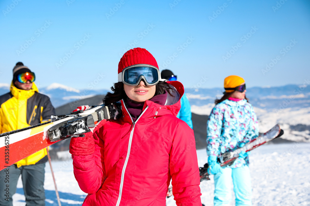 Young woman with ski at resort. Winter vacation