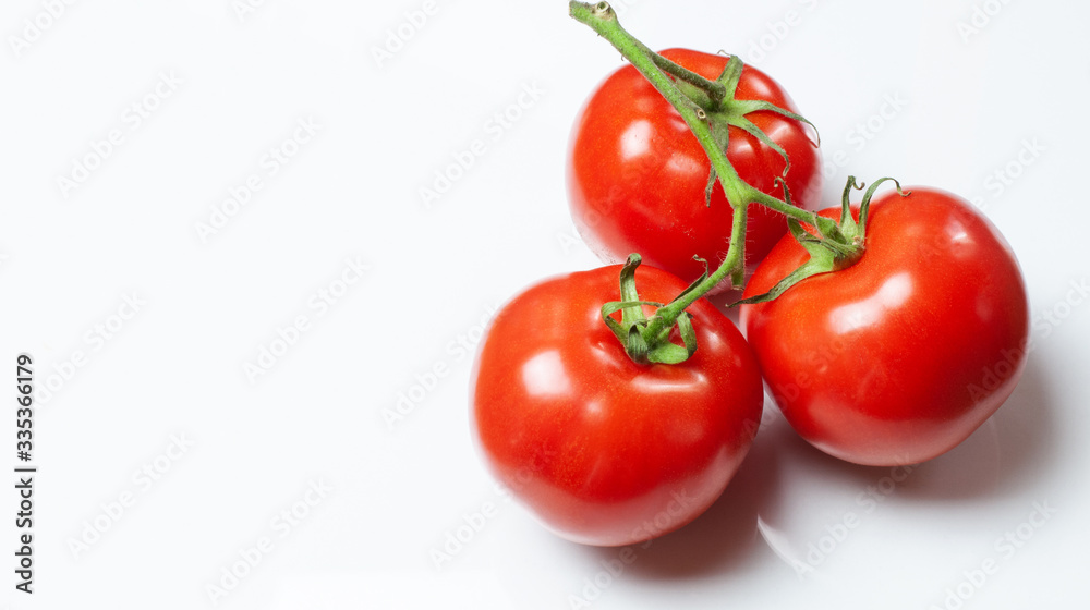 three tomatoes lying on a white background three tomatoes lying on a white background