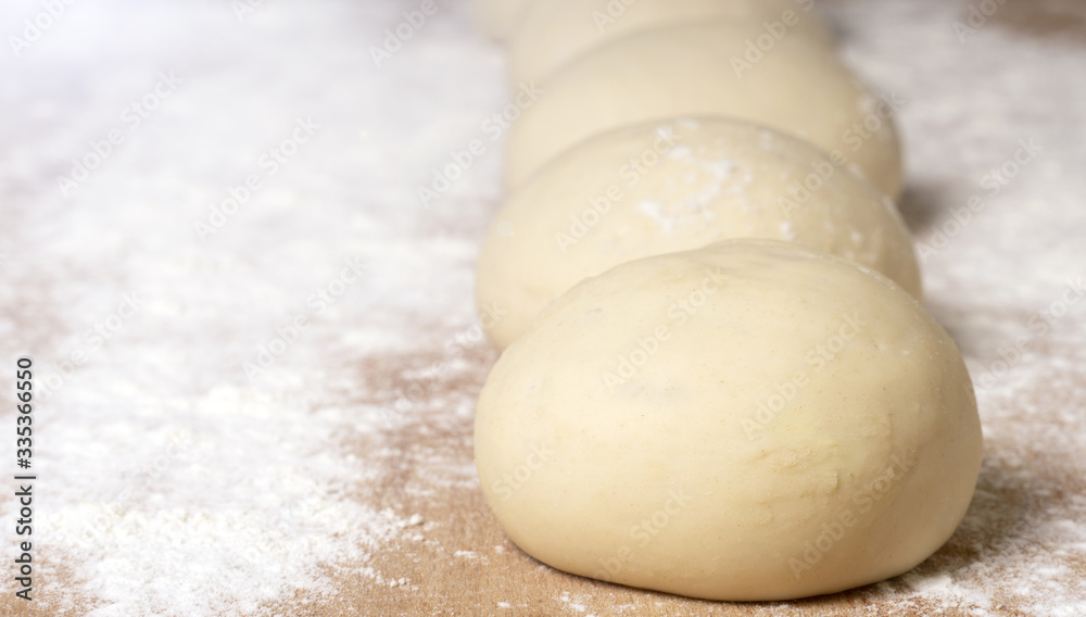 Balls of dough on a wooden board, dough for pizza or pie, selective soft focus Balls of dough on a wooden board, dough for pizza or pie, selective soft focus