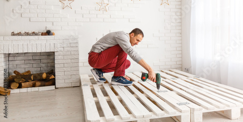 Construction of bed. The man puts the bed frame.