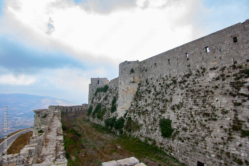 Krak (Crac) des Chevaliers, also called (‎Castle of the Kurds), and formerly Crac de l'Ospital, is a Crusader castle in Syria and one of the most important preserved medieval castles in the world. - obrazy, fototapety, plakaty 