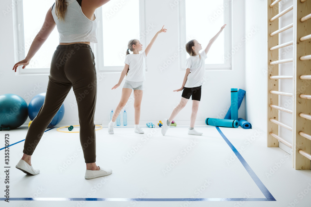 Obraz premium Teenage kids exercising during sport class at school gym