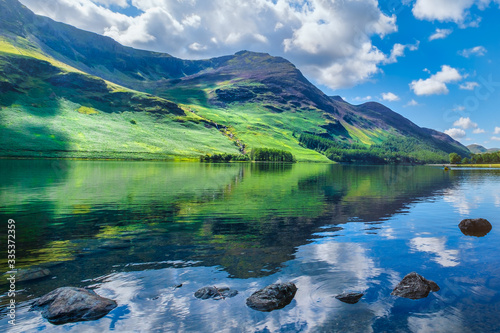 Fotografia, Obraz Mountains reflected on a lake at the beautiful Lake District in England