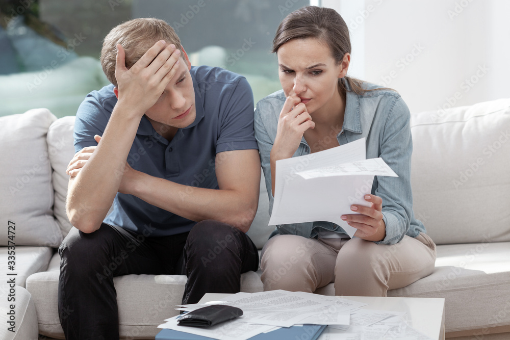 Stressed married couple looking frustrated, having no money to pay off their debts, managing family budget together Stressed married couple looking frustrated, having no money to pay off their debts, managing family budget together
