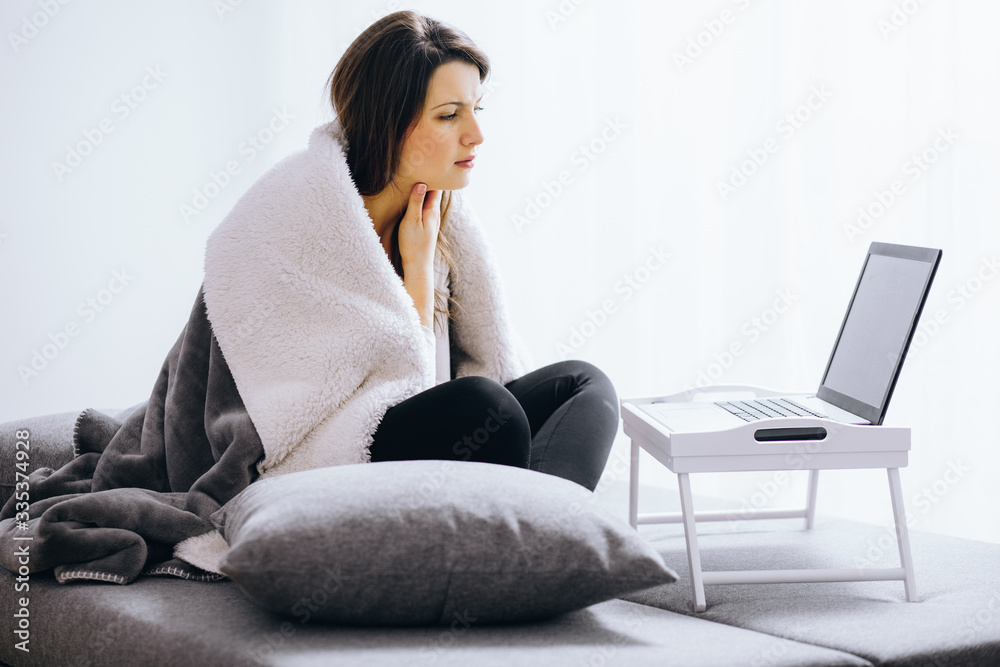 Sick woman with flue sitting at home consulting her doctor via internet conversation Sick woman with flue sitting at home consulting her doctor via internet conversation