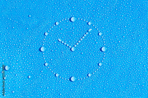 Drops of water in the form of a dial are located on a wet blue background. Dial made of water drops. Abstract blue background. Time is water.