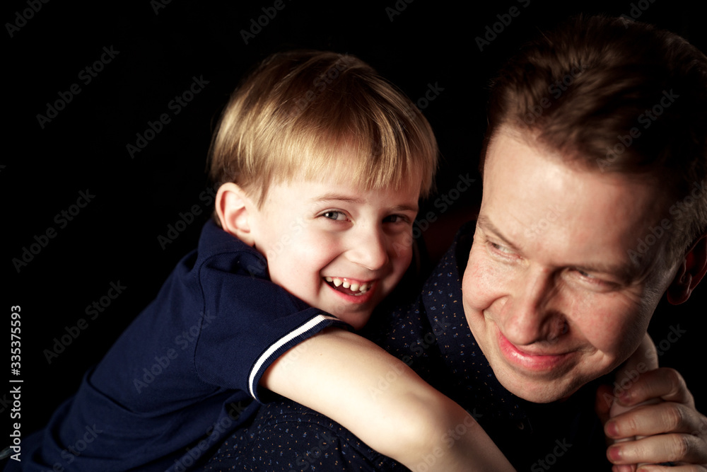 portrait of father with son on black background
portrait of father with son on black background