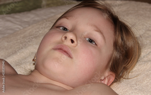 Portrait of a child lying on a bed. Little girl bottom view.