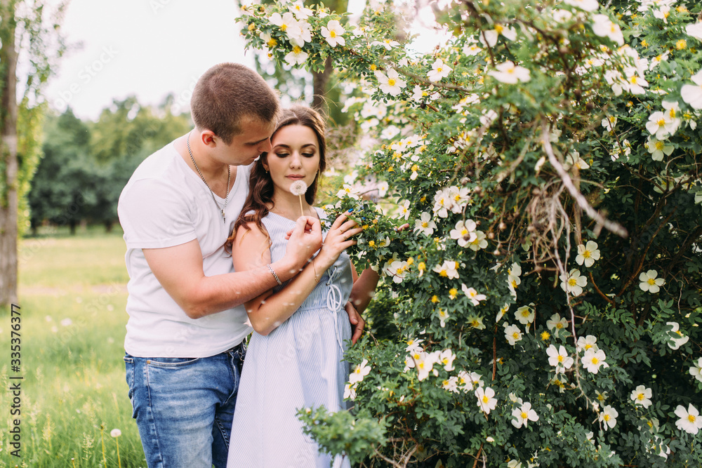 Portrait of a happy couple in love with flowers, hugs, love story, sunny photo Portrait of a happy couple in love with flowers, hugs, love story, sunny photo