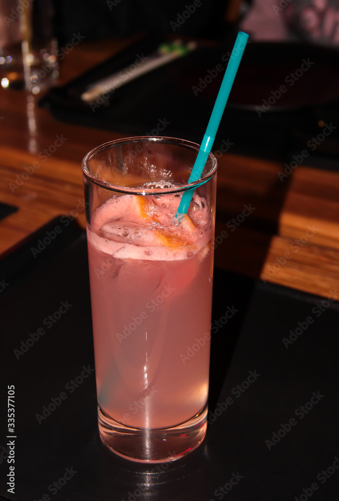 Grapefruit drink in a glass with a straw. Grapefruit drink in a glass with a straw.