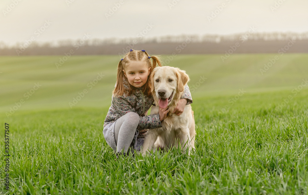 Little girl cuddling dog on field Little girl cuddling dog on field