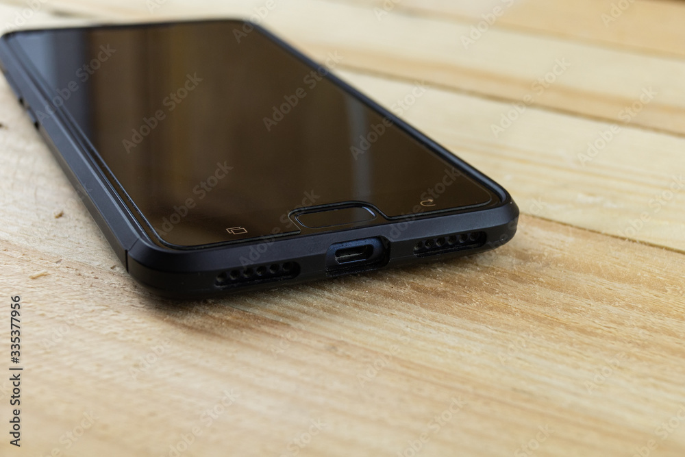 the smartphone is lying on a wooden surface.High technology and the structure of the tree the smartphone is lying on a wooden surface.High technology and the structure of the tree