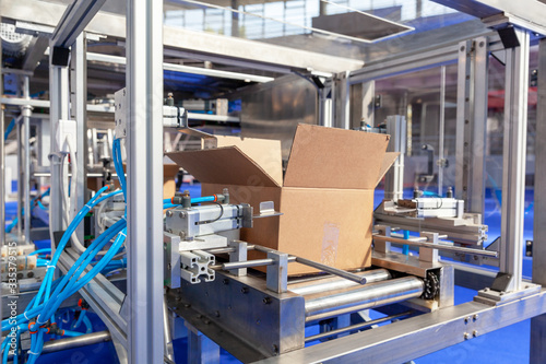 Automatic cardboard package box packaging machine in the empty factory. Financial crisis concept. © wellphoto
