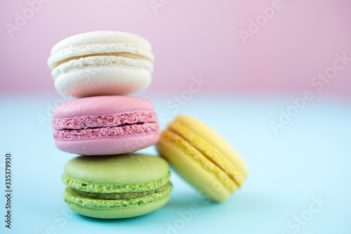 Colorful macarons on pink and blue background
