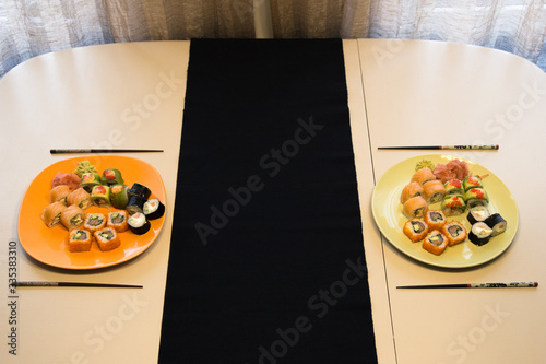 A table for two with a sushi maki set in a minimalist style and warm colors.