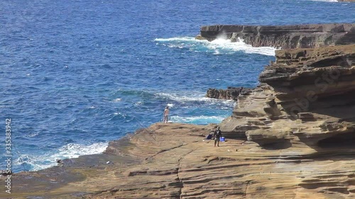 Shore fishermen on the windward side of Oahu cast their lines out into the blue Pacific Ocean on a sunny day.