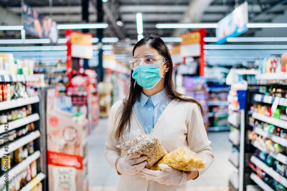 Shopping during pandemic.Buyer wearing a protective mask.Nonperishable purchased household pantry groceries.Quarantine isolatin diet preparation.Dry goods and nutritional foods shopping.Whole grains Shopping during pandemic.Buyer wearing a protective mask.Nonperishable purchased household pantry groceries.Quarantine isolatin diet preparation.Dry goods and nutritional foods shopping.Whole grains
