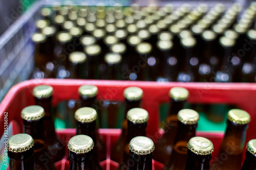 Group of capped beers lined in plastic boxes in a brewery