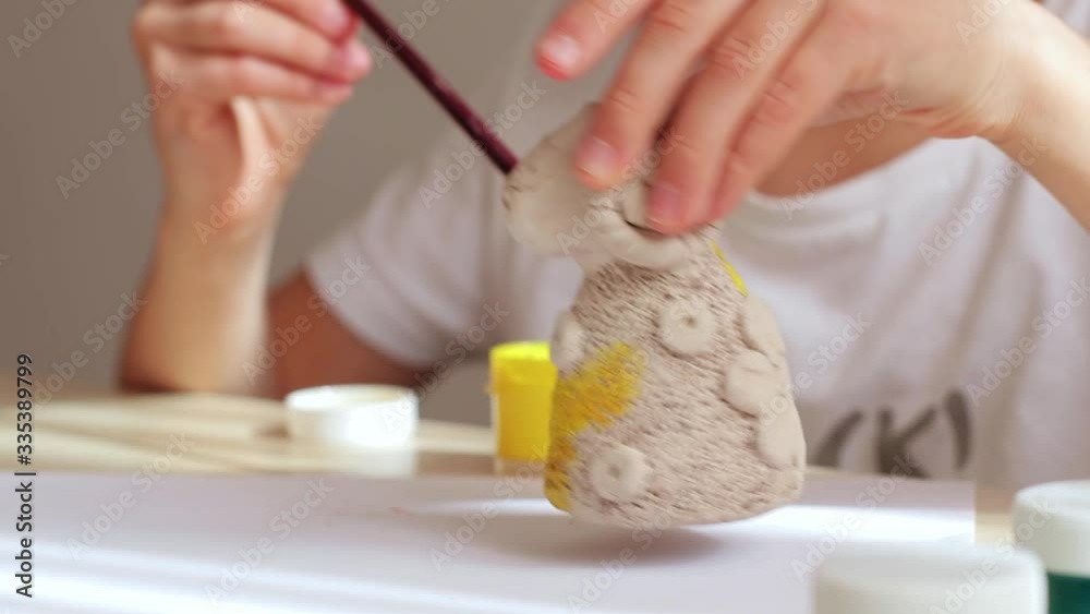 Caucasian child at his place of work in the creative workshop. A painter or a sculptor occupied with their favourite work. Brushes and paint. Inspiration for creativity. Engage in favorite hobby Caucasian child at his place of work in the creative workshop. A painter or a sculptor occupied with their favourite work. Brushes and paint. Inspiration for creativity. Engage in favorite hobby