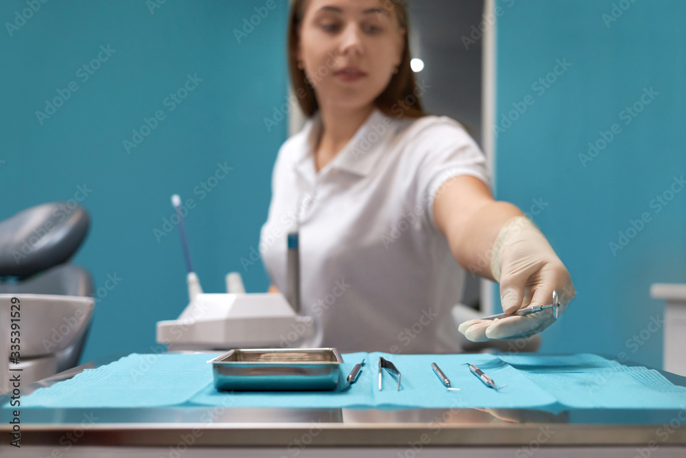 Close up of gloved hand picking dental tools, dentistry, dental equipment. the nurse is preparing the tools for the procedure, Close up of gloved hand picking dental tools, dentistry, dental equipment. the nurse is preparing the tools for the procedure,