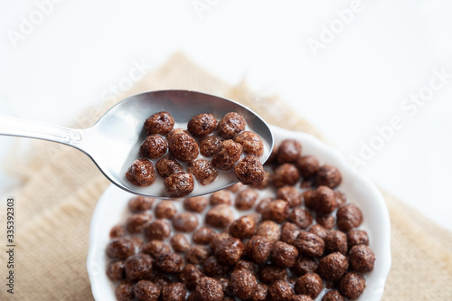 Chocolate balls with milk and a spoon in a white plate
