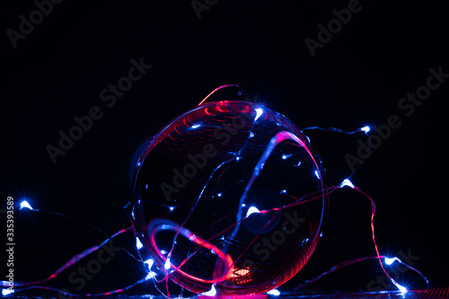 one perfect glass ball is illuminated by coloured lights